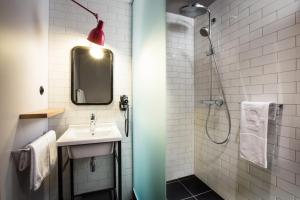 a bathroom with a sink and a shower at pentahotel Paris Charles de Gaulle in Roissy-en-France