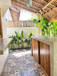 patio z podłogą wyłożoną kafelkami i barem w obiekcie Las Flores Lombok w Kuta Lombok