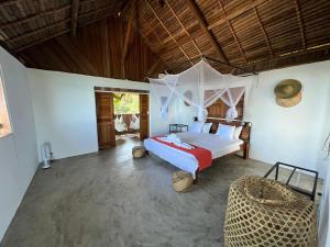 una camera con un letto e una sedia di Canopee Lodge a Nosy Komba