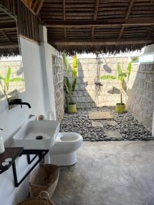 bagno con servizi igienici bianchi e lavandino di Canopee Lodge a Nosy Komba