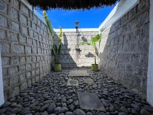 un muro di pietra con un passaggio in pietra con una pianta di Canopee Lodge a Nosy Komba