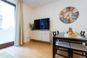 een eetkamer met een tafel en een klok aan de muur bij Urban Oasis with free parking in Boedapest