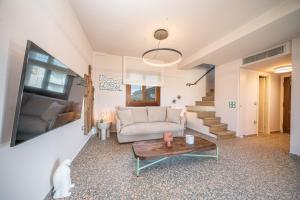 un soggiorno con divano e tavolo di Pink Panther Maisonette Suite ad Argostoli