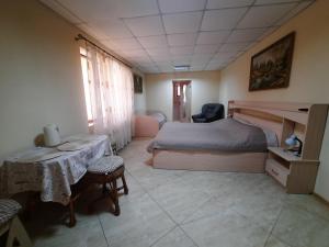 Schlafzimmer mit einem Bett, einem Tisch und Stühlen in der Unterkunft КОМФОРТ in Karpaty