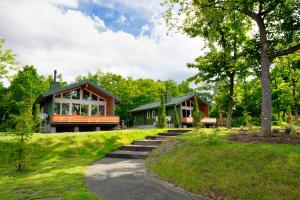 una casa nel bosco con un sentiero che la porta di Chill Village a Biei