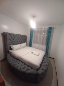 Ліжко або ліжка в номері Jacky's Milimani suites