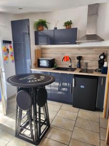 een keuken met een zwarte tafel en een aantal stoelen bij L'esterel in Fréjus