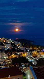 Blick auf eine Stadt in der Nacht mit dem Mond in der Unterkunft Apartments Tati in Ulcinj