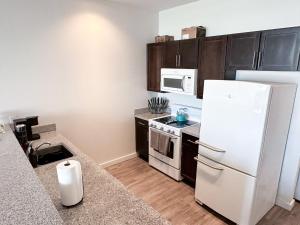 uma cozinha com um frigorífico branco e um micro-ondas em Entire High-Rise Apartment - 2BD em Baton Rouge