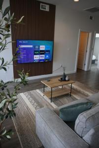 uma sala de estar com um sofá, uma mesa e uma televisão em Stylish Downtown High-Rise - 2BD em Baton Rouge