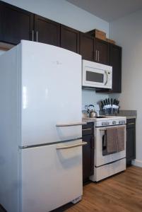 uma cozinha com um frigorífico branco e um micro-ondas em Stylish Downtown High-Rise - 2BD em Baton Rouge