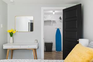 One bedroom apartment Moncton North ! في مونكتون: غرفة نوم مع مرآة ومكتب وطاولة ركوب الأمواج