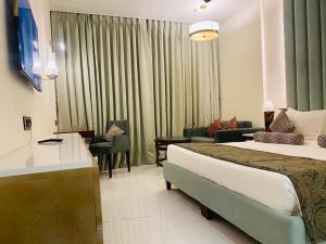 een hotelkamer met 2 bedden en een woonkamer bij Evershine Resort & Spa in Mahabaleshwar