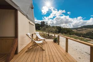 una mecedora sentada en una terraza de madera en I Sicomori - Seme di Carota - Glamping e appartamenti con piscina a Saturnia, en Saturnia