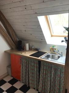 cocina con fregadero y ventana en Appart dans longère Normande au coeur de la Forêt de Lyons, 