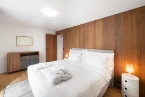 - une chambre avec un lit et des serviettes blanches dans l'établissement Swiss Hotel Apartments - Engelberg, à Engelberg