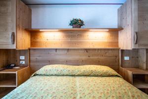 een slaapkamer met een bed met houten kasten en een plant bij Hotel Bijou in Valtournenche