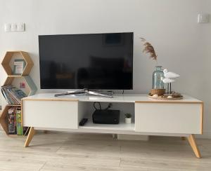 a white entertainment center with a flat screen tv on it at Apartament Horizon in Gdynia