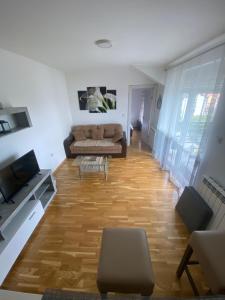 a living room with a couch and a wooden floor at Apartman Una in Čačak