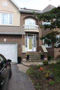 een huis met een auto ervoor geparkeerd bij Leila's Place-Family Deluxe Basement Apartment in Gatineau