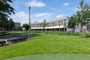 un bâtiment avec un parc et deux bancs devant lui dans l'établissement Luxury room with king size bed, à Dordrecht