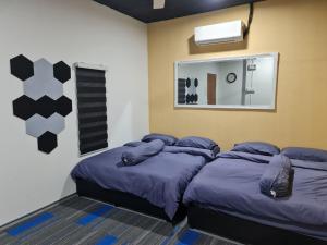 - une chambre avec 2 lits et un miroir dans l'établissement Ayden Hostel Airport Transit - KLIA, à Sepang