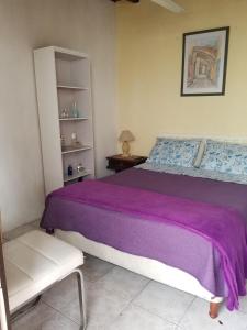 una camera con letto viola e sedia di La Casa de Teresa a Colonia del Sacramento