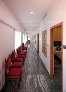 une rangée de chaises rouges dans un couloir hospitalier dans l'établissement Hotel Wayanad Stay, à Kalpatta