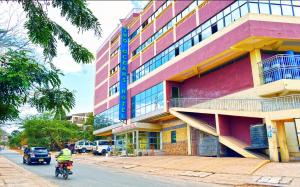 a person riding a motorcycle in front of a building at Two Oceans Hotel Voi in Voi