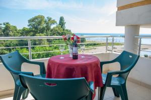 einen Tisch mit Weingläsern und Blumen auf dem Balkon in der Unterkunft Villa Fici in Ulcinj