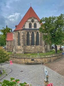 eine alte Steinkirche mit rotem Dach in der Unterkunft City Appartements Arnstadt in Arnstadt