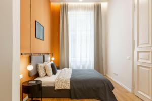 a bedroom with a bed with orange walls and a window at Luxurious Minimalist Residence with Sauna by Prestige Homes in Budapest