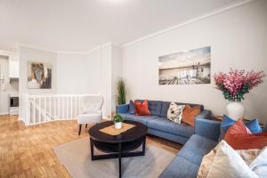 sala de estar con sofá azul y mesa en Rosen Apartment, en Bergen