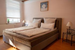 a bedroom with a bed with white sheets and pillows at Café Burgstraße in Wernigerode