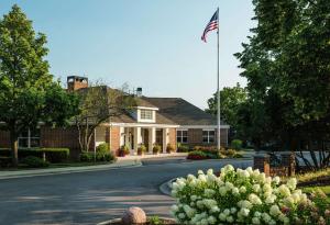 Uma casa com uma bandeira americana à frente. em Homewood Suites by Hilton Chicago - Schaumburg em Schaumburg