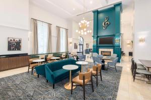 Homewood Suites by Hilton New Orleans في نيو أورلينز: لوبي به طاولات وكراسي وموقد