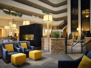 a lobby of a hotel with blue chairs and yellow pillows at Hilton Fort Collins in Fort Collins