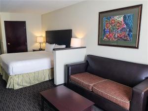 een hotelkamer met een bed en een bank bij Oxford Suites Portland - Jantzen Beach in Portland