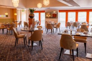 a dining room filled with tables and chairs at Hilton Northampton Hotel in Northampton