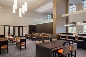 Hampton Inn & Suites Rosemont Chicago O'Hare في روزمونت: غرفة طعام مع طاولات وكراسي وبار