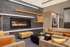 Hampton Inn & Suites Rosemont Chicago O'Hare في روزمونت: غرفة معيشة مع موقد وأريكة