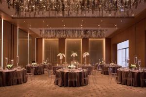 a ballroom with tables and chairs and a chandelier at Conrad Washington DC in Washington