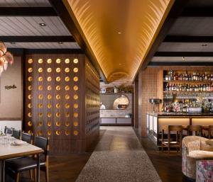 un ristorante con soffitto dorato e un bar di C. Baldwin, Curio Collection by Hilton a Houston