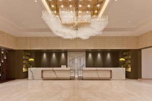 a lobby with a large chandelier and a reception desk at DoubleTree By Hilton Jaipur Amer in Jaipur