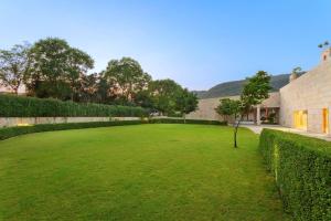 a large grassy yard with a tree in the middle at DoubleTree By Hilton Jaipur Amer in Jaipur