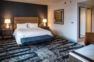 1 dormitorio con 1 cama y 1 reposapiés azul en The Yorktowne Hotel, Tapestry Collection by Hilton, en York