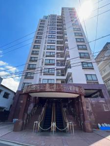 ein hohes weißes Gebäude mit einer Treppe davor in der Unterkunft Hiroshima Ekimae Universal Hotel in Hiroshima