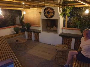 a woman sitting on a bench in a room with a fireplace at Best Area Close to Leeds Centre in Leeds