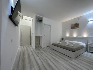 um quarto com uma cama num quarto branco em CagliariParadiseApartment it Marina em Cagliari