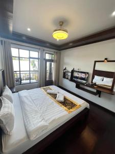 um quarto com uma cama grande e uma janela em Namkhan Riverview Boutique House em Luang Prabang